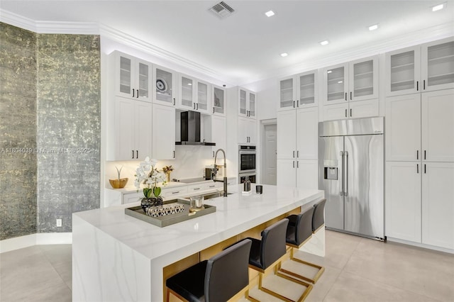 10881 Hawks Vista St, Plantation, FL 33324 - kitchen with stainless steel appliances, white cabinets, an island with sink, light tile patterned floors, and a breakfast bar