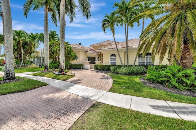 10881 Hawks Vista St, Plantation, FL 33324 - mediterranean / spanish home with stucco siding, a front yard, a tile roof, and decorative driveway