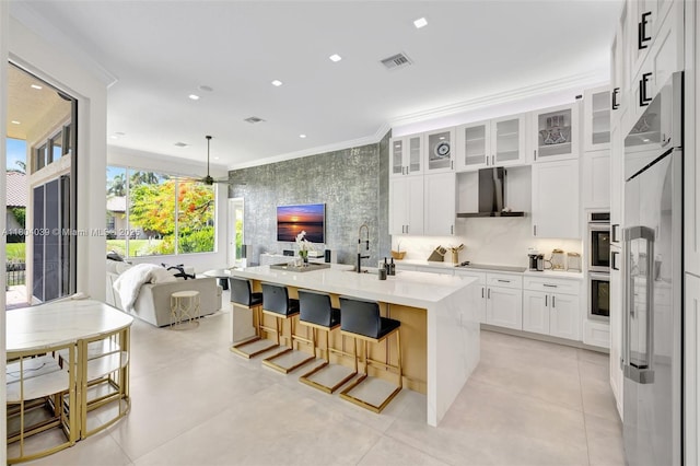 10881 Hawks Vista St, Plantation, FL 33324 - kitchen with wall chimney range hood, appliances with stainless steel finishes, ornamental molding, open floor plan, and white cabinetry