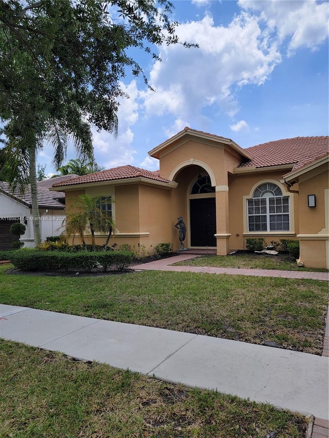 4149 E Gardenia Ave, Weston, FL 33332 - mediterranean / spanish home with a tile roof, stucco siding, and a front lawn