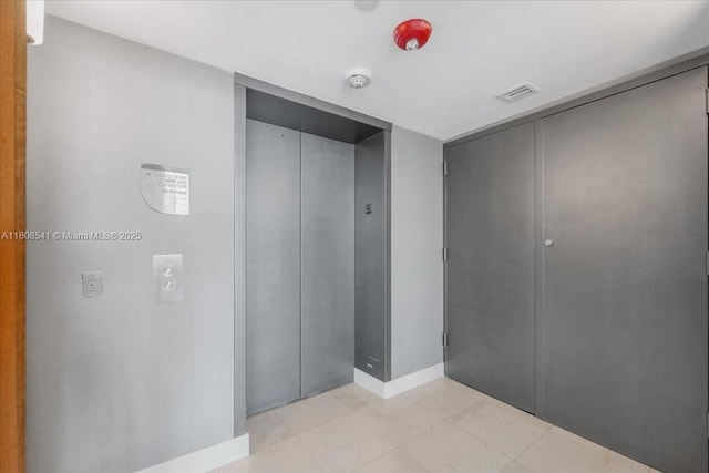 2127 Brickell Ave Unit 2302, Miami, FL 33129 - corridor featuring elevator, light tile patterned flooring, and baseboards