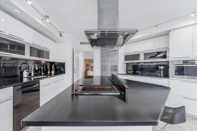 2127 Brickell Ave Unit 2302, Miami, FL 33129 - kitchen with island range hood, appliances with stainless steel finishes, dark countertops, and a center island