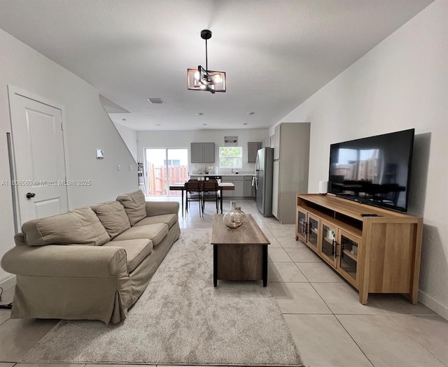 245 NE 3rd Ct, Florida City, FL 33034 - living room featuring light tile patterned flooring, baseboards, and a chandelier