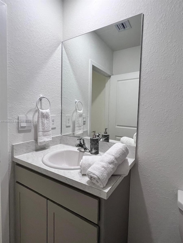 245 NE 3rd Ct, Florida City, FL 33034 - bathroom with vanity, a textured wall, and toilet