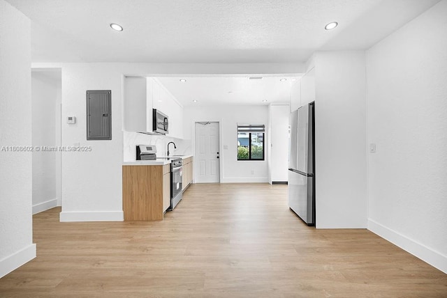 12400 NE 11th Ct, North Miami, FL 33161 - kitchen featuring appliances with stainless steel finishes, electric panel, light countertops, baseboards, and light wood finished floors