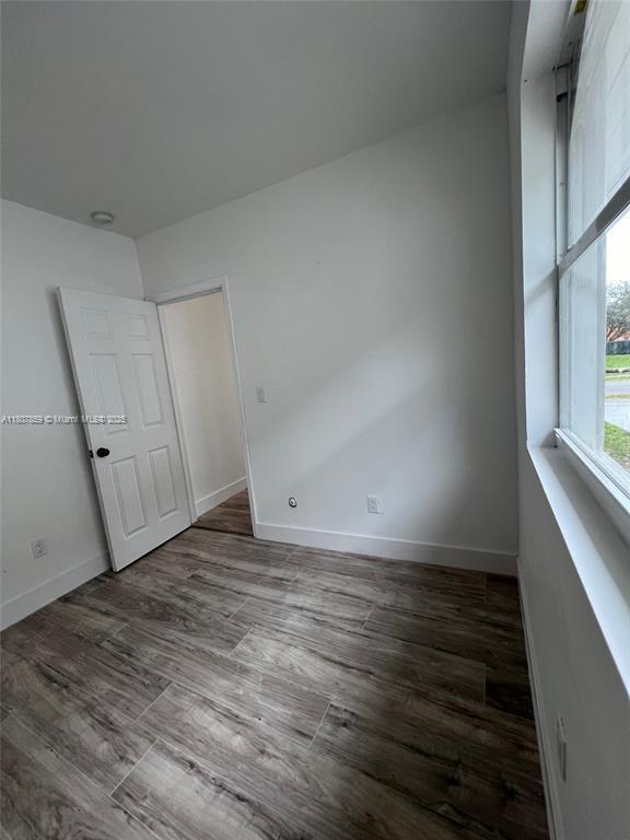 2 SW 6th Ave, Dania Beach, FL 33004 - unfurnished bedroom featuring wood finished floors and baseboards