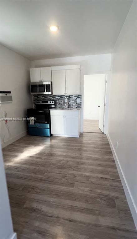 2 SW 6th Ave, Dania Beach, FL 33004 - kitchen with electric stove, stainless steel microwave, white cabinets, baseboards, and recessed lighting