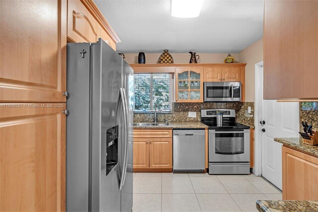 1901 SW 37th Ave, Miami, FL 33145 - kitchen featuring appliances with stainless steel finishes, a sink, stone counters, tasteful backsplash, and light tile patterned flooring