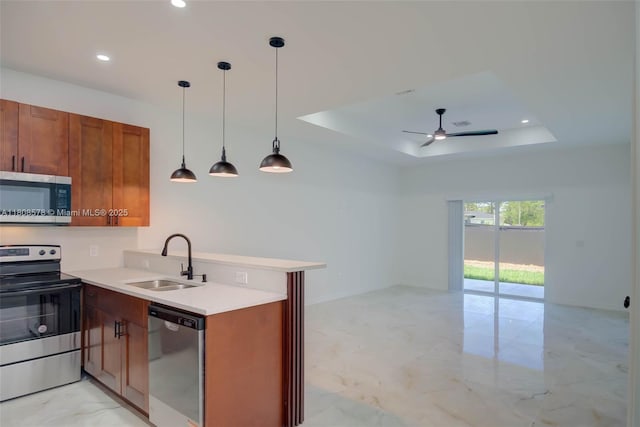 921 Winters St E, Lehigh Acres, FL 33974 - kitchen featuring appliances with stainless steel finishes, a sink, a peninsula, a raised ceiling, and open floor plan