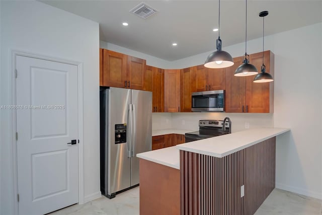 921 Winters St E, Lehigh Acres, FL 33974 - kitchen featuring stainless steel appliances, a peninsula, light countertops, brown cabinets, and hanging light fixtures