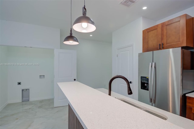 921 Winters St E, Lehigh Acres, FL 33974 - kitchen featuring stainless steel fridge, pendant lighting, brown cabinetry, a sink, and recessed lighting