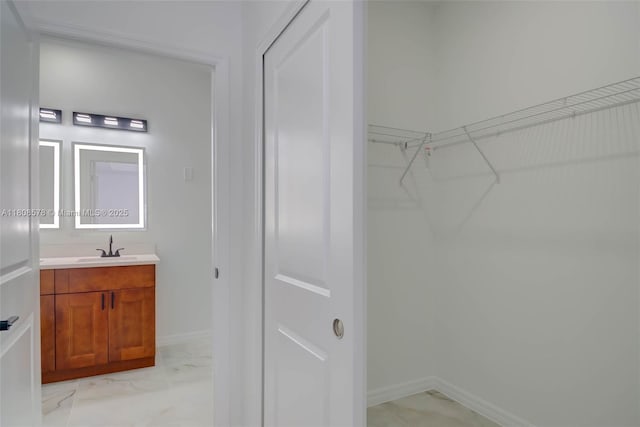 921 Winters St E, Lehigh Acres, FL 33974 - bathroom featuring vanity, marble finish flooring, baseboards, and a walk in closet