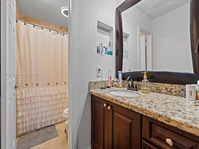 12749 SW 71st Ter, Miami, FL 33183 - full bathroom featuring a textured wall, vanity, toilet, tile patterned flooring, and a textured ceiling