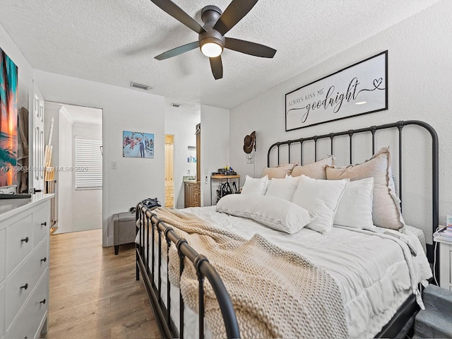 12749 SW 71st Ter, Miami, FL 33183 - bedroom with wood finished floors, a textured ceiling, a ceiling fan, and ensuite bath