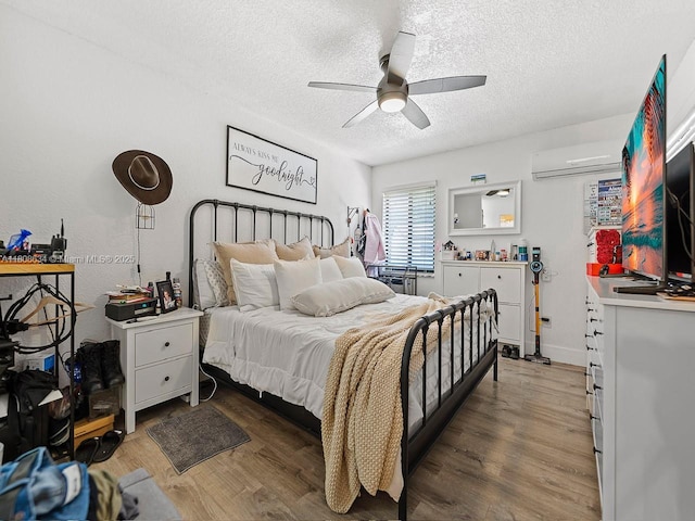 12749 SW 71st Ter, Miami, FL 33183 - bedroom with a textured ceiling, a wall unit AC, wood finished floors, and a ceiling fan