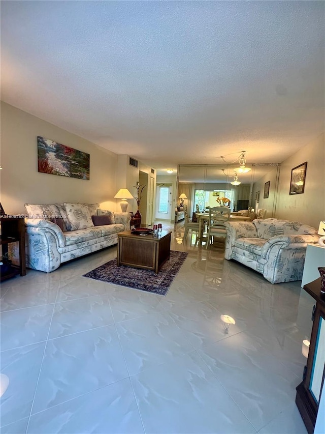 700 NE 14th Ave Unit 204, Hallandale Beach, FL 33009 - living room featuring a textured ceiling and marble finish flooring