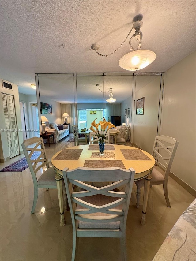 700 NE 14th Ave Unit 204, Hallandale Beach, FL 33009 - dining room with a textured ceiling and baseboards