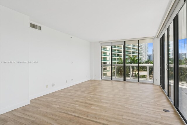 20185 E Country Club Dr Unit 505, Aventura, FL 33180 - empty room with light wood-style flooring, a wall of windows, and baseboards