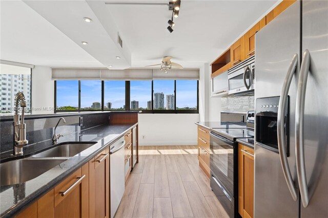 20185 E Country Club Dr Unit 505, Aventura, FL 33180 - kitchen with appliances with stainless steel finishes, a sink, brown cabinetry, tasteful backsplash, and ceiling fan