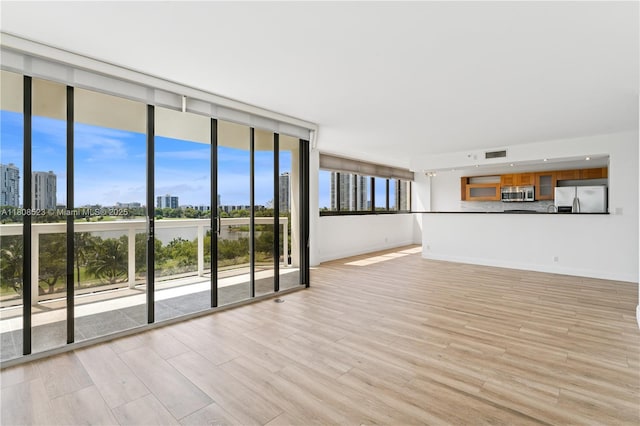 20185 E Country Club Dr Unit 505, Aventura, FL 33180 - unfurnished living room with light wood-type flooring, baseboards, a skyline view, and expansive windows