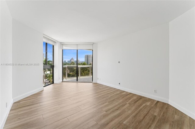 20185 E Country Club Dr Unit 505, Aventura, FL 33180 - empty room with expansive windows, wood finished floors, and baseboards