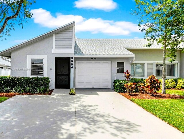 8886 Windtree St, Boca Raton, FL 33496 - view of front of property with stucco siding, an attached garage, driveway, and a shingled roof