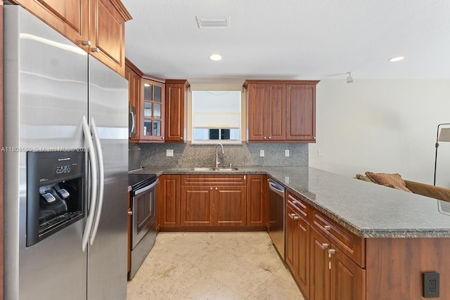 2922 Catalina St Unit 2922, Miami, FL 33133 - kitchen with appliances with stainless steel finishes, a peninsula, a sink, decorative backsplash, and brown cabinets