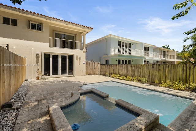 2922 Catalina St Unit 2922, Miami, FL 33133 - view of swimming pool featuring a pool with connected hot tub, a fenced backyard, a patio area, and french doors