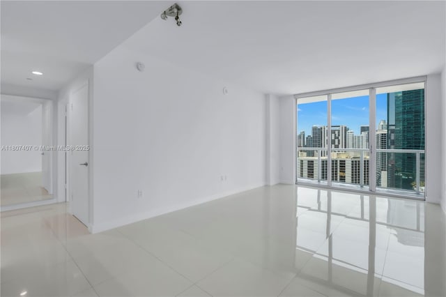 500 Brickell Ave Unit 3103, Miami, FL 33131 - spare room featuring tile patterned flooring, a wall of windows, a view of skyline, and baseboards