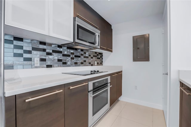 500 Brickell Ave Unit 3103, Miami, FL 33131 - kitchen with stainless steel appliances, electric panel, light countertops, dark brown cabinetry, and backsplash