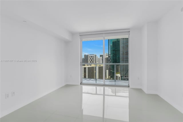 500 Brickell Ave Unit 3103, Miami, FL 33131 - empty room featuring floor to ceiling windows, tile patterned flooring, and a view of city