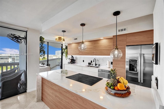 1000 W Island Blvd Unit 611, Aventura, FL 33160 - kitchen with stainless steel appliances, modern cabinets, a sink, hanging light fixtures, and light stone counters