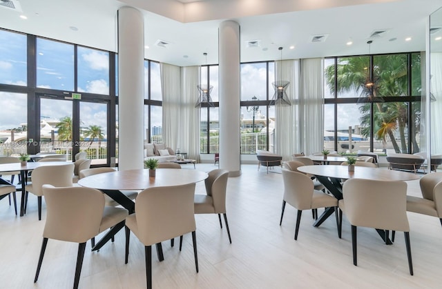 1000 W Island Blvd Unit 611, Aventura, FL 33160 - dining space featuring a wall of windows, a high ceiling, and light wood-style floors