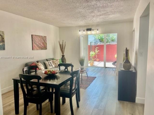 200 NW 107th Ave Unit 106, Miami, FL 33172 - dining space with a textured ceiling, light wood-style floors, and baseboards