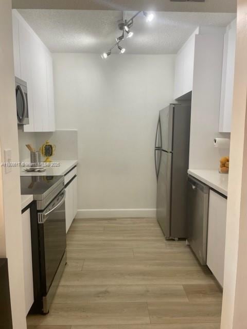 200 NW 107th Ave Unit 106, Miami, FL 33172 - kitchen with appliances with stainless steel finishes, white cabinets, light countertops, and baseboards