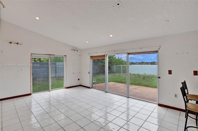8749 NW 189th Ter, Hialeah, FL 33018 - spare room featuring a textured ceiling, a water view, lofted ceiling, baseboards, and recessed lighting
