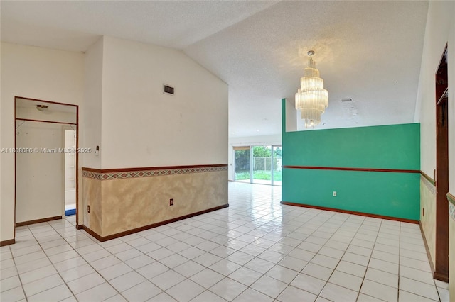 8749 NW 189th Ter, Hialeah, FL 33018 - empty room with a chandelier, a wainscoted wall, lofted ceiling, a textured ceiling, and baseboards
