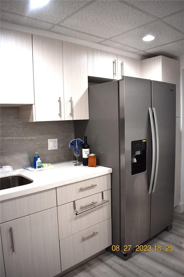 3901 S Ocean Dr Unit 11A, Hollywood, FL 33019 - kitchen with stainless steel fridge, light countertops, light wood-style flooring, and a paneled ceiling