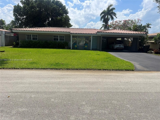 4441 NE 17th Ave, Oakland Park, FL 33334 - single story home featuring a carport, a front yard, and asphalt driveway