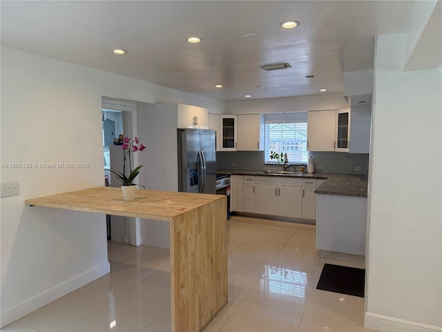 4441 NE 17th Ave, Oakland Park, FL 33334 - kitchen featuring stainless steel appliances, white cabinetry, recessed lighting, backsplash, and glass insert cabinets
