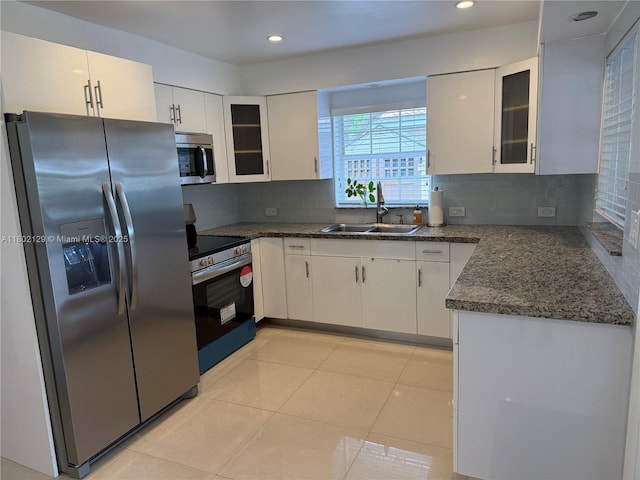 4441 NE 17th Ave, Oakland Park, FL 33334 - kitchen featuring stainless steel appliances, white cabinetry, decorative backsplash, glass insert cabinets, and recessed lighting