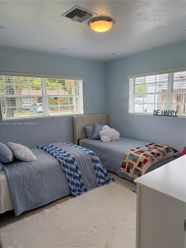 4441 NE 17th Ave, Oakland Park, FL 33334 - bedroom with multiple windows and wood finished floors