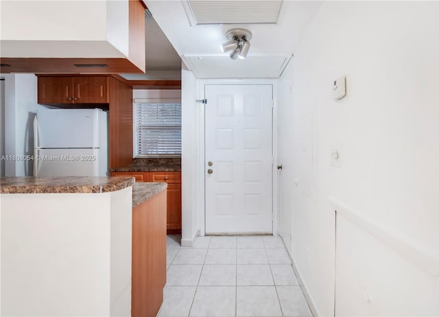 11604 NW 11th St, Pembroke Pines, FL 33026 - kitchen with freestanding refrigerator, light tile patterned floors, dark countertops, and brown cabinetry
