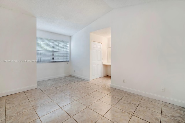 11604 NW 11th St, Pembroke Pines, FL 33026 - empty room featuring vaulted ceiling, light tile patterned flooring, and baseboards