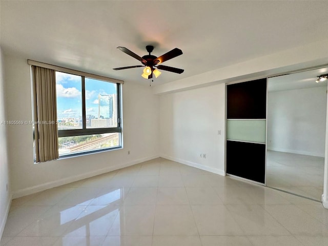 90 SW 3rd St Unit 1208, Miami, FL 33130 - unfurnished bedroom with baseboards, light tile patterned flooring, a closet, and a ceiling fan