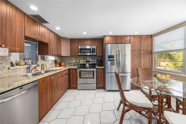 2504 Antigua Ter Unit O3, Coconut Creek, FL 33066 - kitchen featuring appliances with stainless steel finishes, a sink, backsplash, light stone counters, and recessed lighting