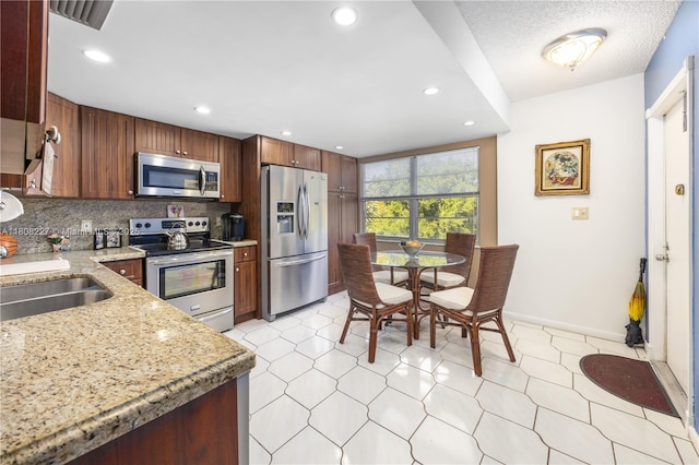 2504 Antigua Ter Unit O3, Coconut Creek, FL 33066 - kitchen with appliances with stainless steel finishes, tasteful backsplash, light stone countertops, recessed lighting, and a sink