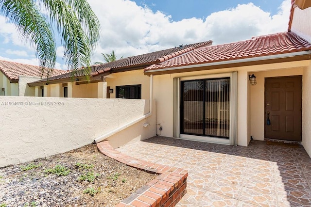 17359 NW 66th Ct, Hialeah, FL 33015 - property entrance with stucco siding, a tiled roof, and a patio