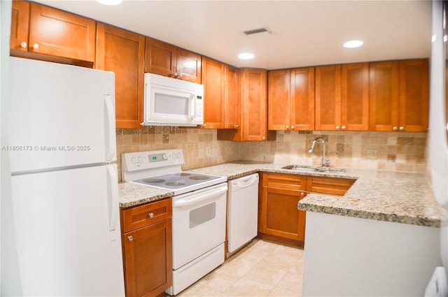 733 SE 1st Way Unit 206, Deerfield Beach, FL 33441 - kitchen with white appliances, decorative backsplash, brown cabinets, light stone countertops, and recessed lighting