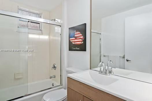 185 SE 14th Ter Unit 1410, Miami, FL 33131 - bathroom with toilet, vanity, and bath / shower combo with glass door